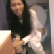 An Asian-American girl video-records her mother taking a shit while sitting on a toilet. She describes the smell as she laughs. Her mom seems annoyed. No loud pooping sounds.